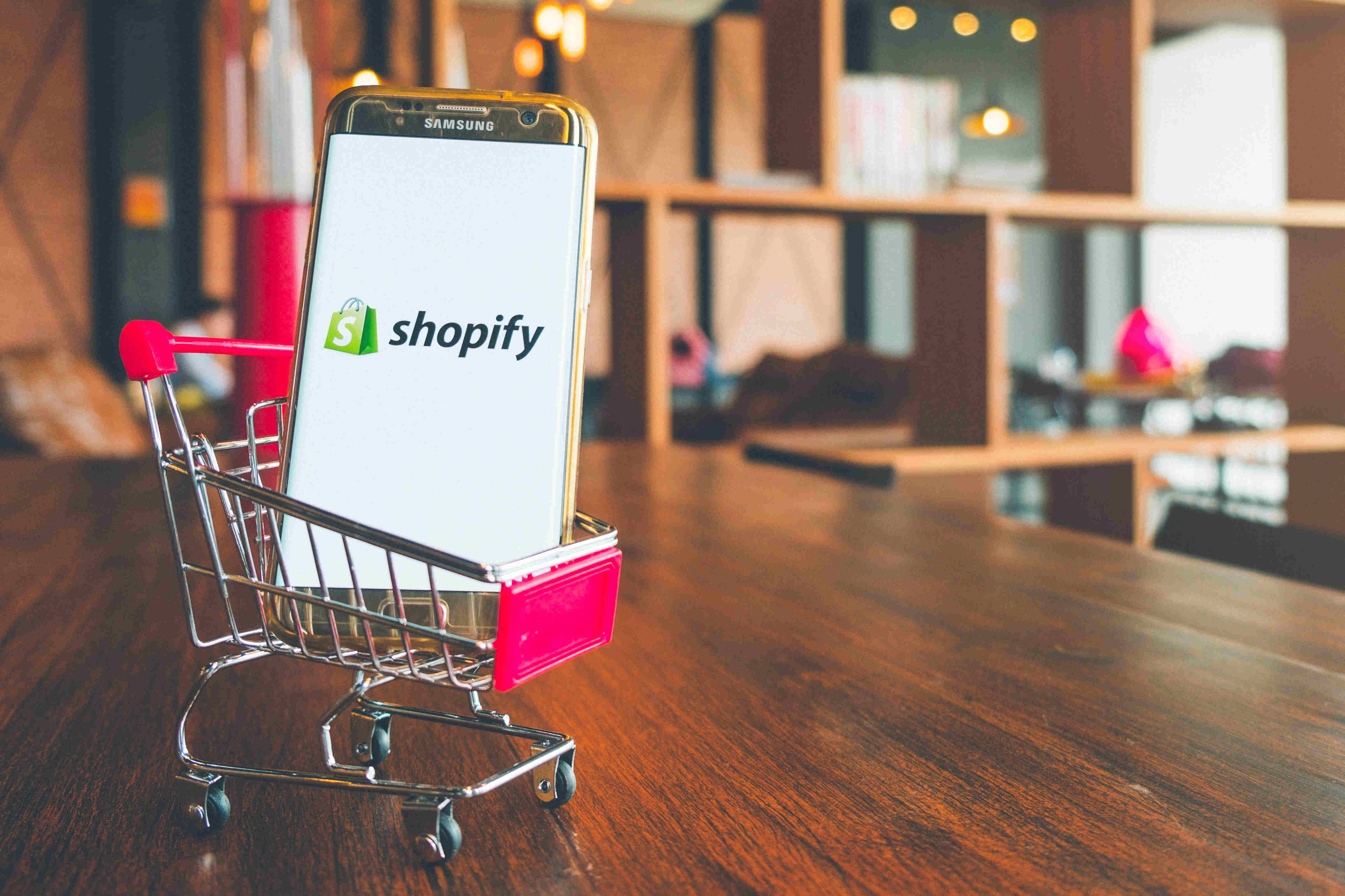 shopify logo on mobile in a shooping trolley